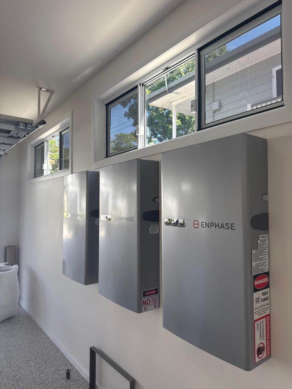 Three wall-mounted home batteries in a Bulimba garage
