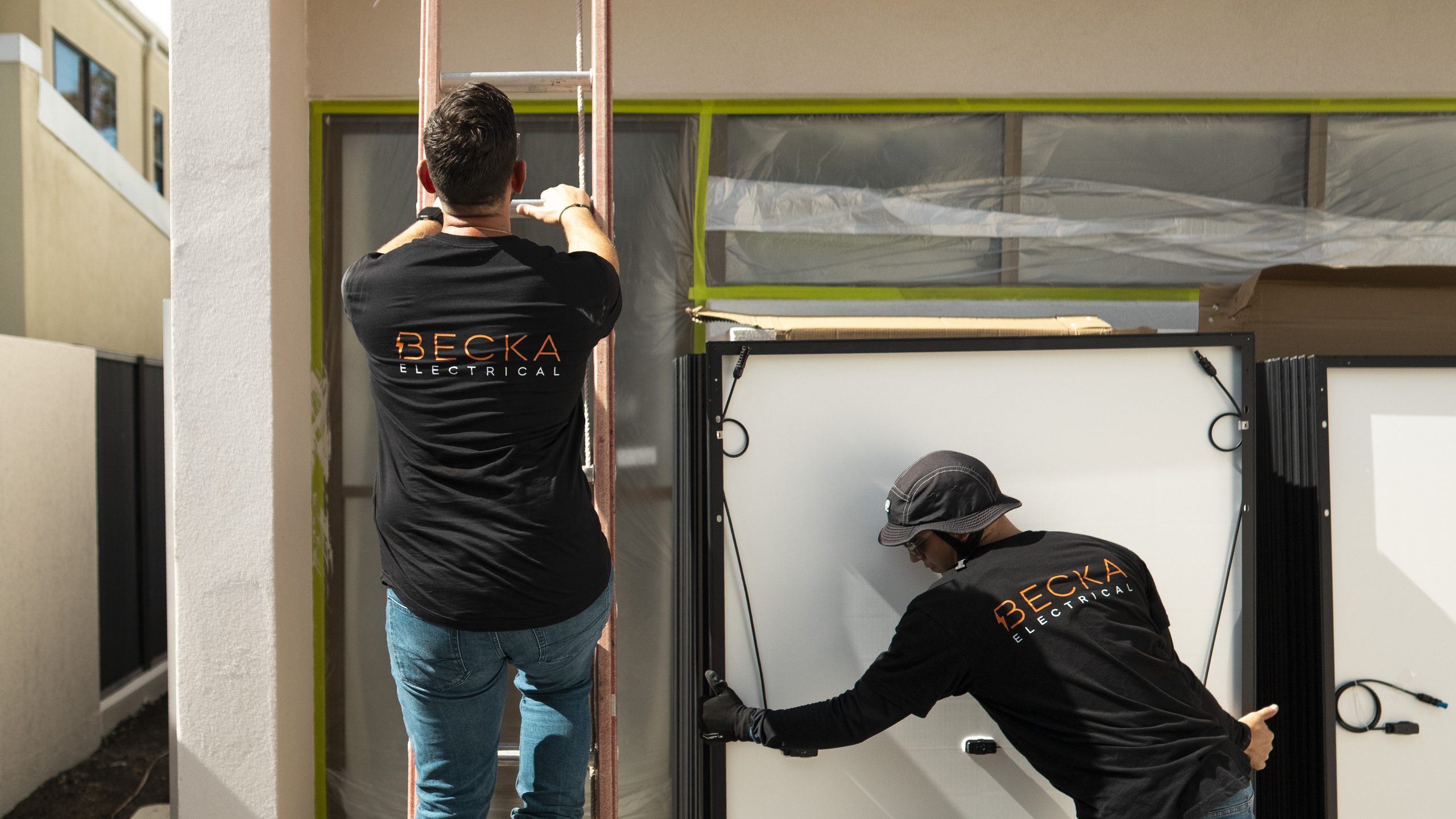 Two Becka electricians positioning equipment at a garage installation.