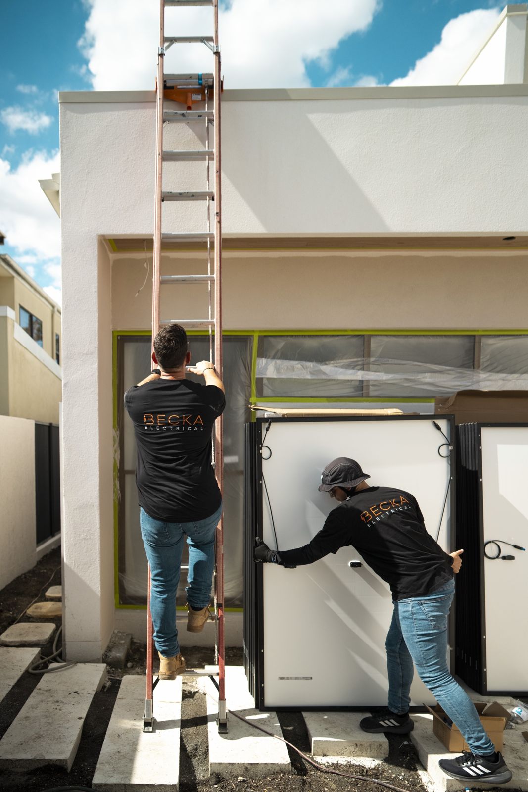 Two people installing rooftop solar panels.