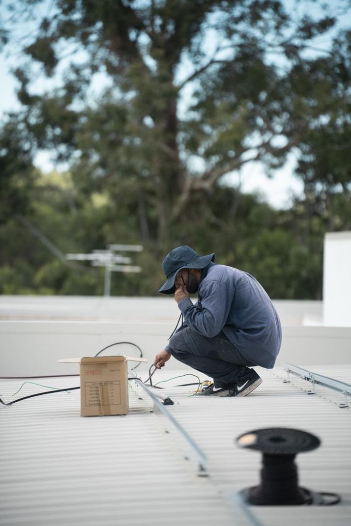 Crew member working on a metal roof.